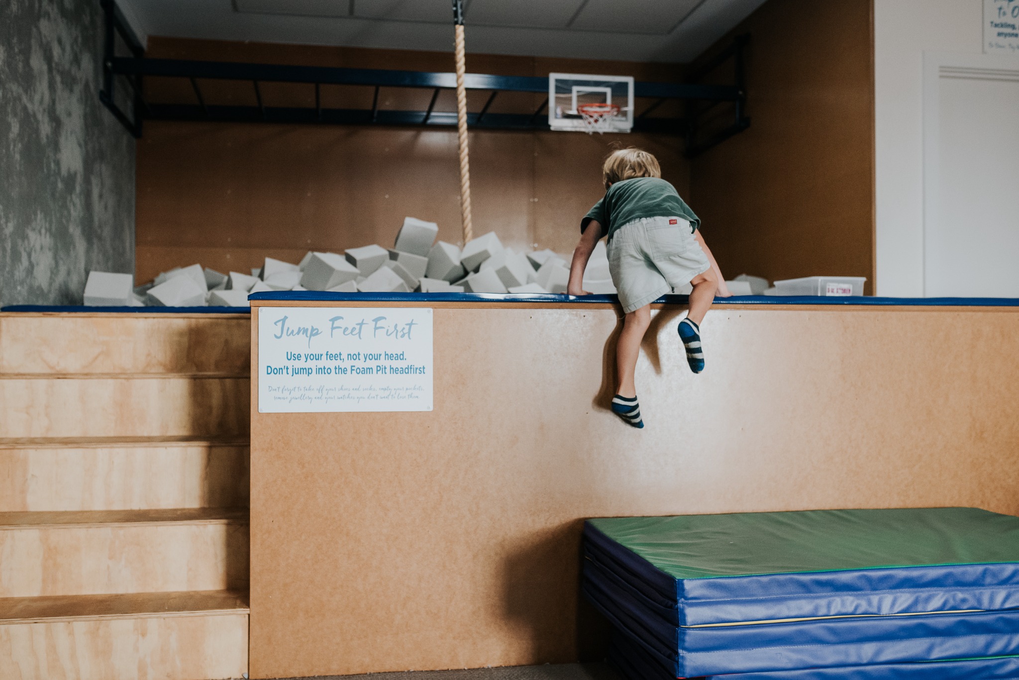 A child climbing into a foam pit