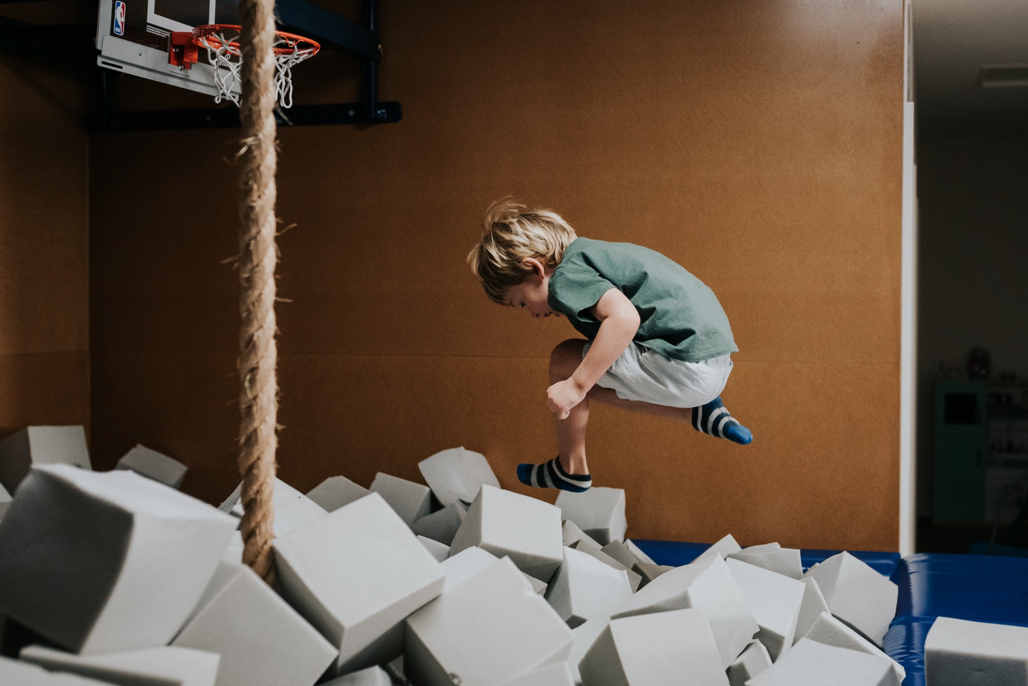 A child jumping confidently into a foam pit