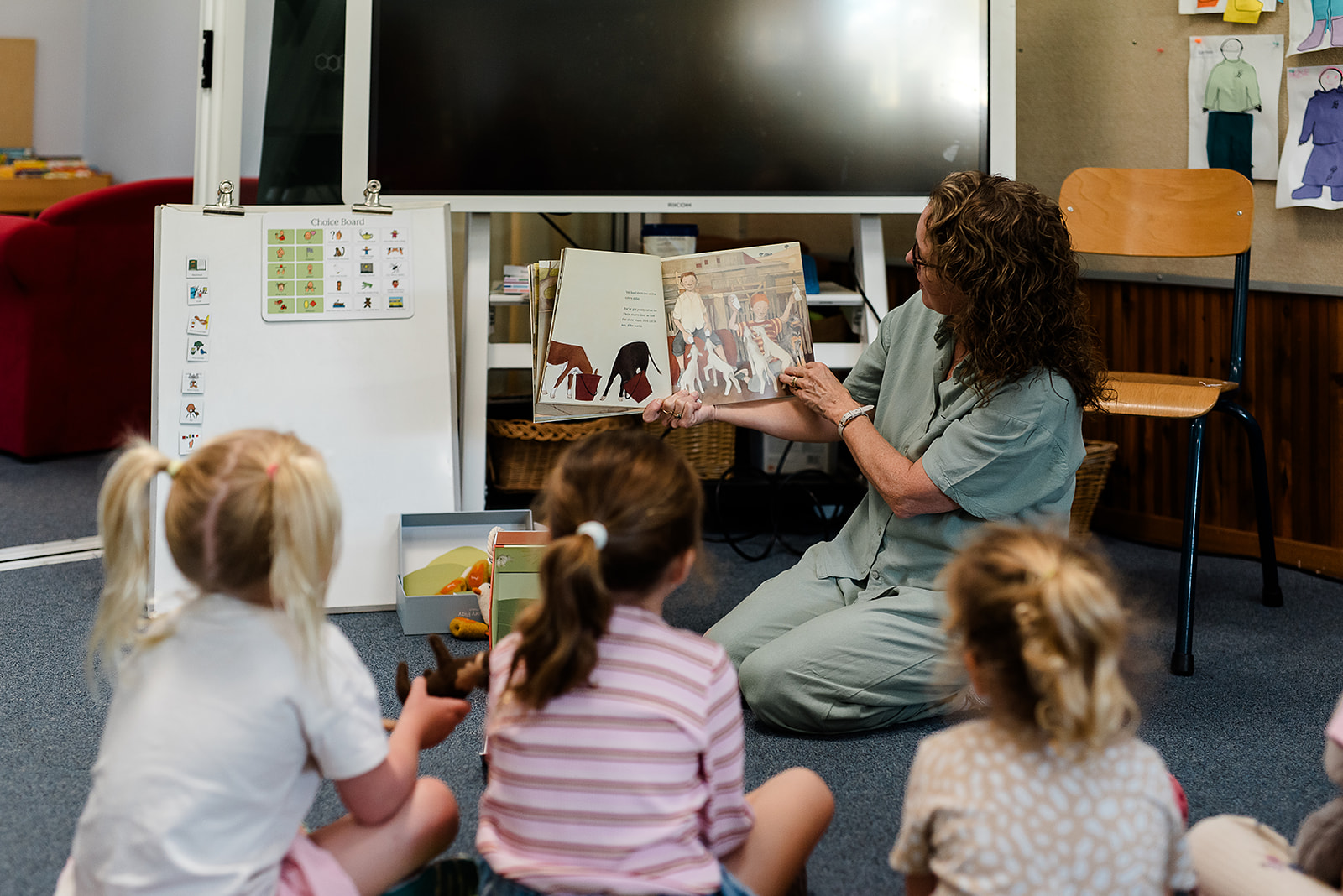 An educator reading with a group of young children